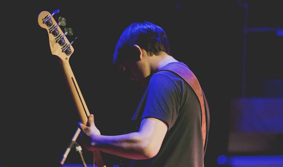 bassist playing on stage alone