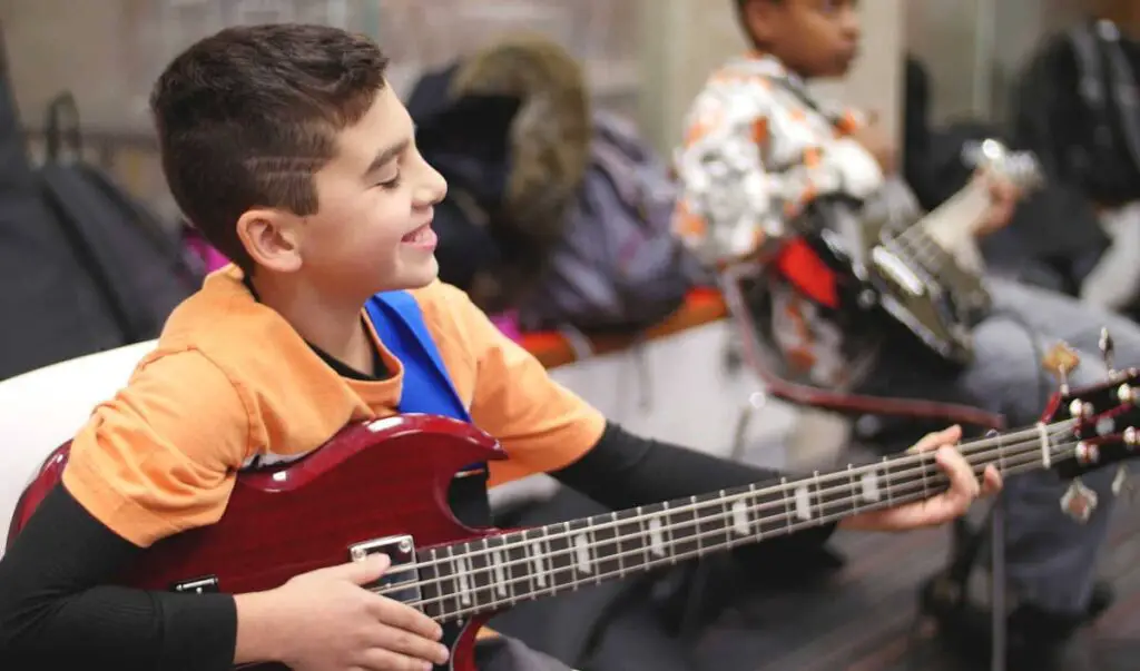 child playing a short-scale bass guitar