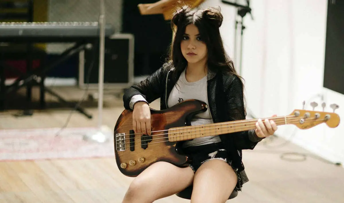 female bassist playing bass without amp