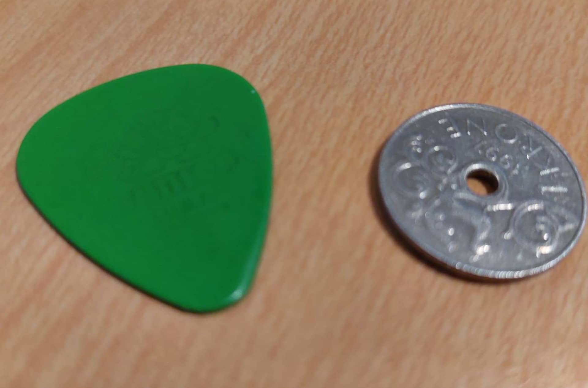 bass pick and coin laying on table