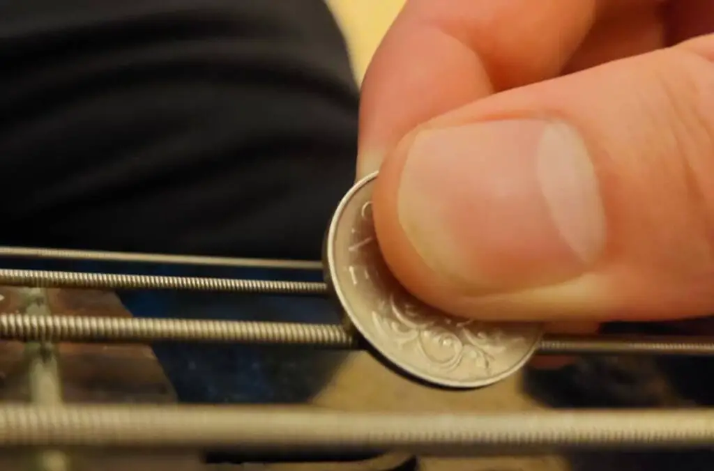coin being used as pick on 4-string bass