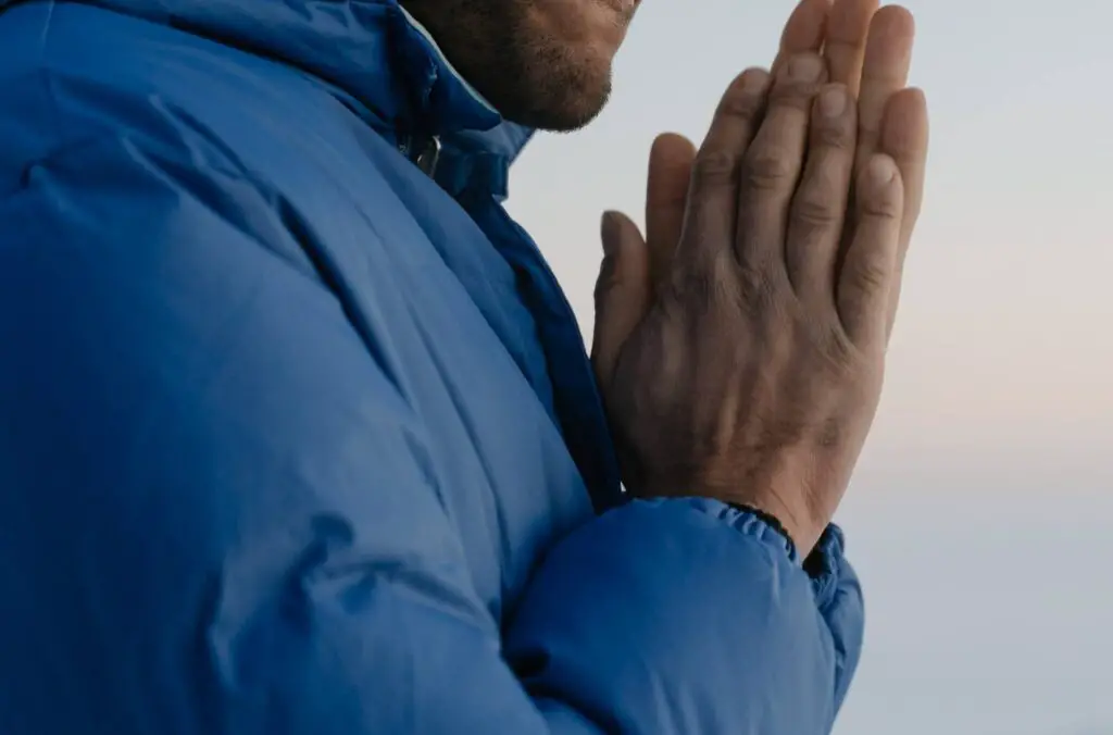 man with chronic cold fingers rubbing hands together