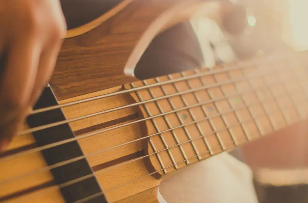 bassist playing 6-string bass with low action