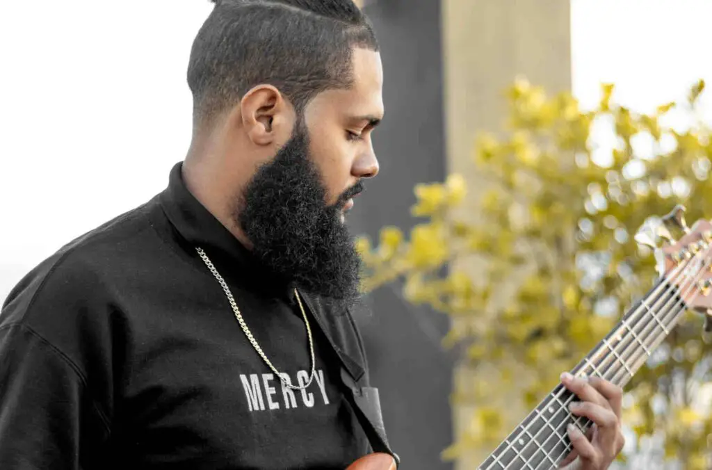 5-string bass player tuning his instrument