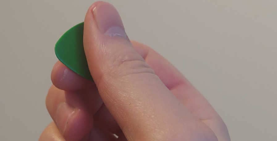 bass pick being held by right hand