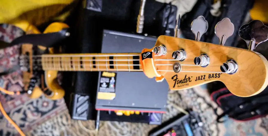 fender jazz bass resting next to bass amplifier