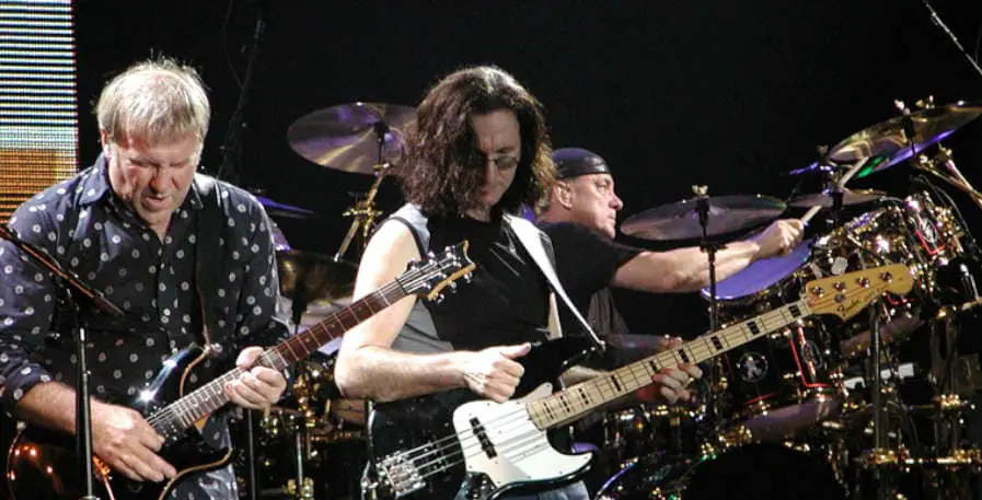 geddy lee picking his fender jazz bass during rush concert