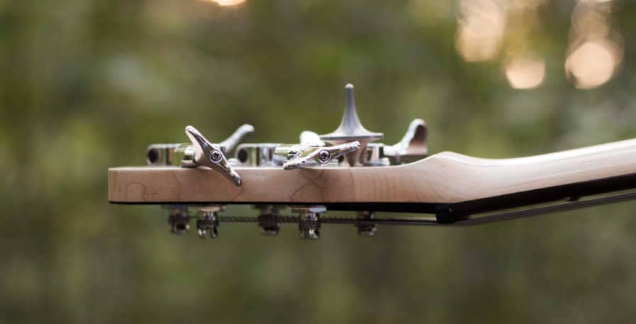 headstock of bass guitar with flatwound strings strung onto it