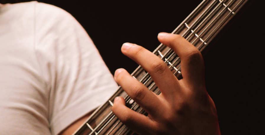 5-string bass guitar with thick strings being fretted