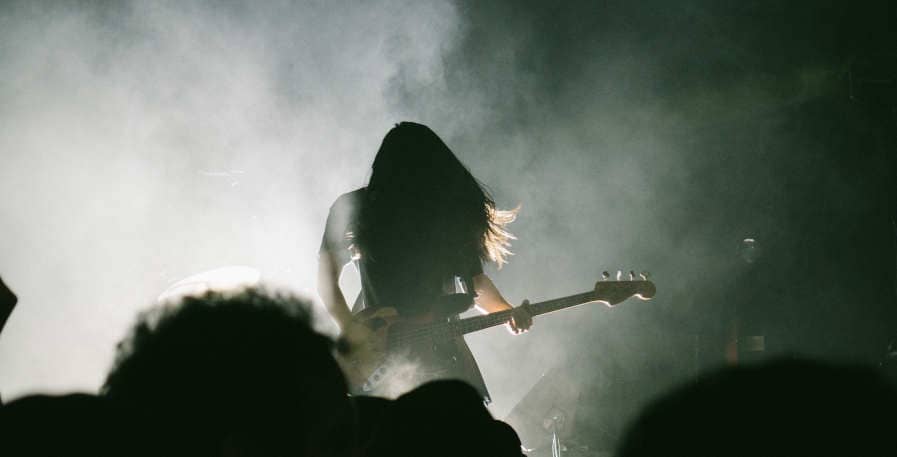 bassists playing 4-string bass in drop a live on stage