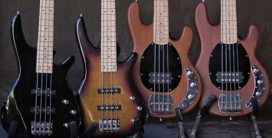 various bass guitars stored on stands