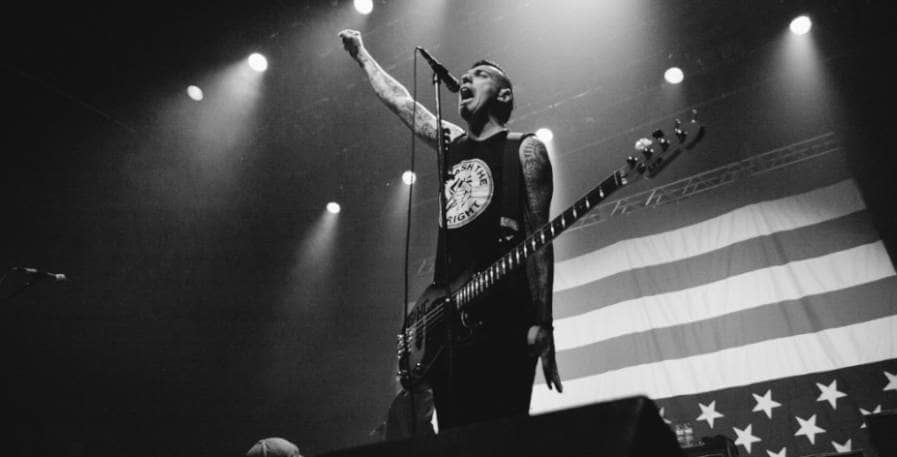 punk bassist standing on stage with 4-string bass