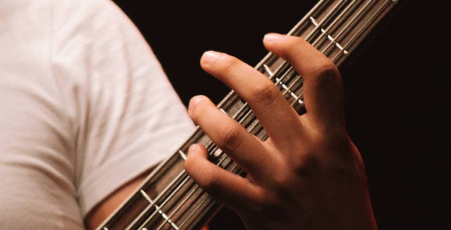 bassist playing a bass fill on a 4-string bass guitar