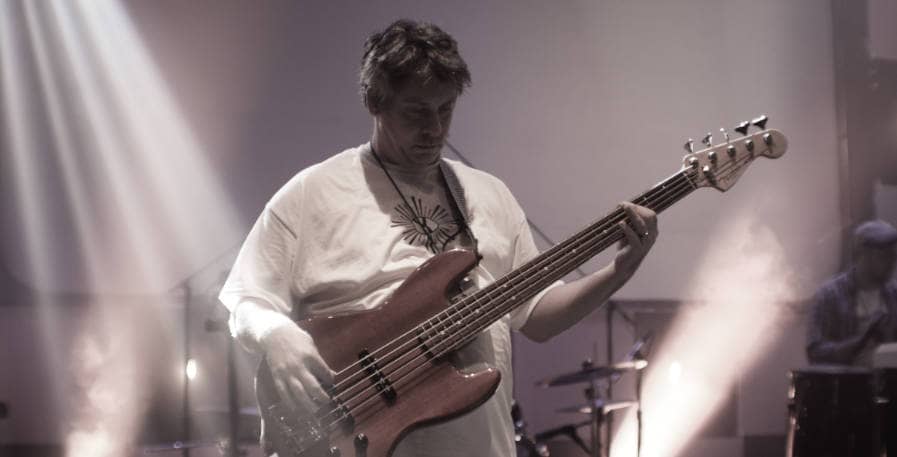 old bass player playing 5-string bass live