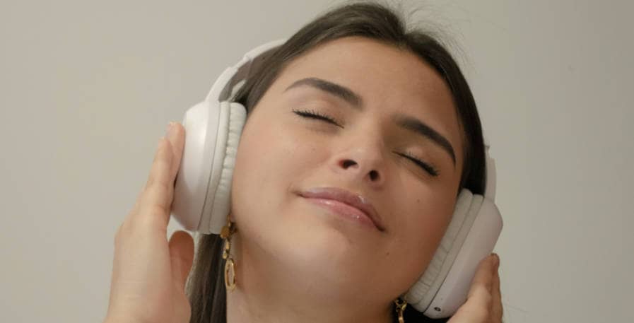 woman listening intently to music on headphones