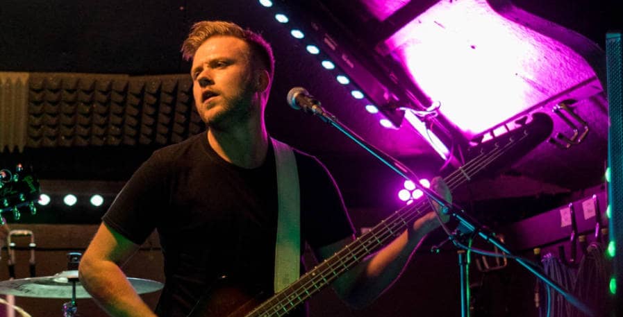 young bass player playing a gibson thunderbird