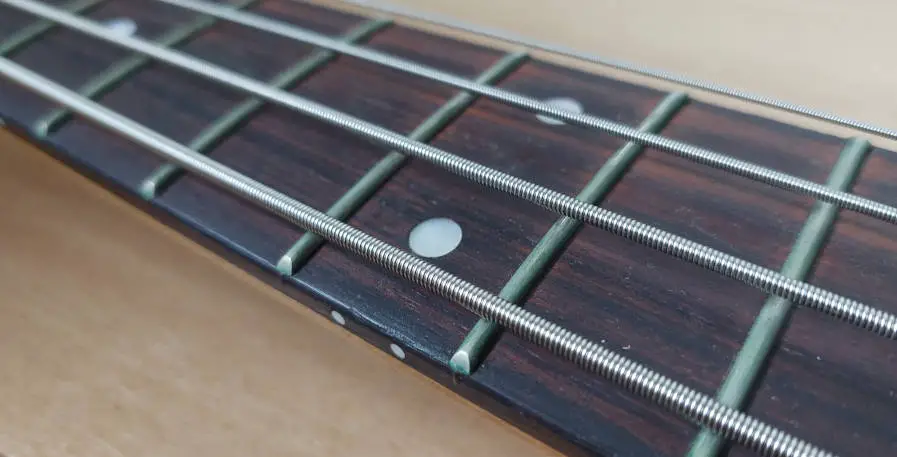 Dots and fretmarkers on the 12th fret of a bass guitar