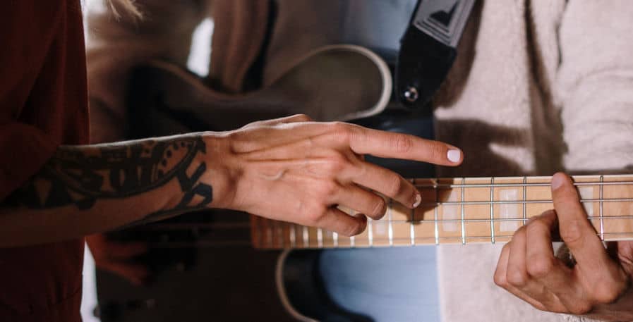 bassist getting feedback from tutor on how to play the bass