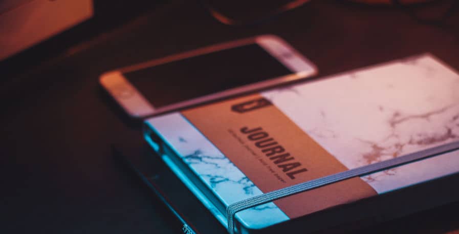 journal and smartphone laying on top of table