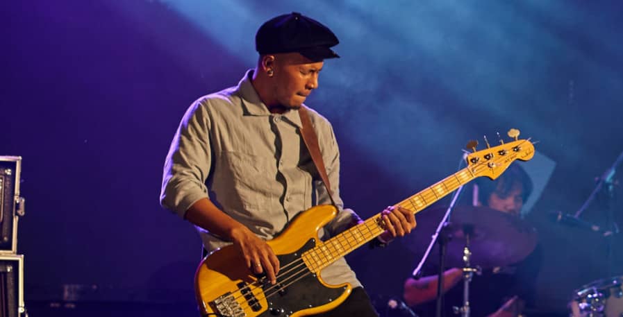 rock bassist playing bass live on stage